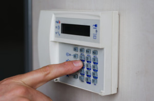 Finger pressing keys on alarm keypad